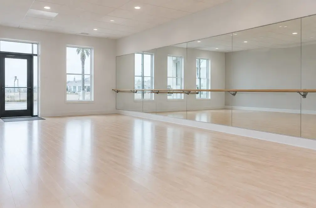 Illustration: an Oxnard dance studio with a pale maple floor, a mirror wall and a barre, freshly painted lines near the entry
